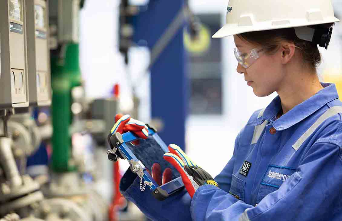 Schlumberger Worker Inspecting Equipment Wearing HSE Gear